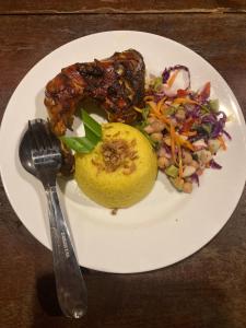 a plate of food with meat and salad on a table at North Pagai Bungalows in Pulau Silabusabeu +16 photos