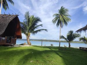 a resort with palm trees and a body of water at North Pagai Bungalows in Pulau Silabusabeu