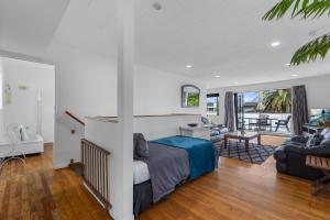 a bedroom with a bed and a living room at Beach Haven - Papamoa Beach Escape in Papamoa