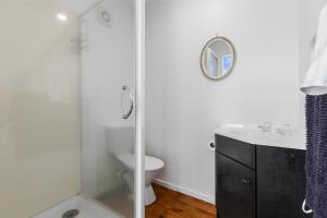 a bathroom with a shower and a toilet and a sink at Beach Haven - Papamoa Beach Escape in Papamoa +10 photos