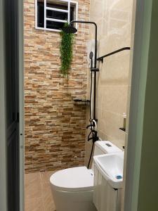 a bathroom with a toilet and a brick wall at RusanHome Pengkalan Chepa in Pengkalan Cepa +4 photos