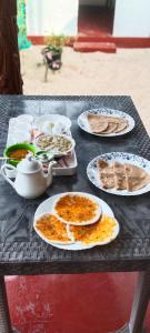 een zwarte tafel met borden met voedsel erop bij Marari Red Angel in Mararikulam