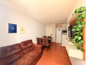 a living room with a brown couch and a table at Apto Confortável - Supermercado Bahamas ao lado in Uberaba
