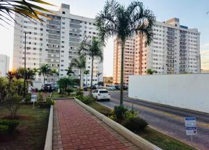 a street with palm trees in front of a large building at Apto Confortável - Supermercado Bahamas ao lado in Uberaba +22 photos
