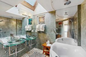 a bathroom with two sinks and a bath tub at Spectacular Oceanfront Studio with Hot Tub & Loft in Fort Bragg +25 photos