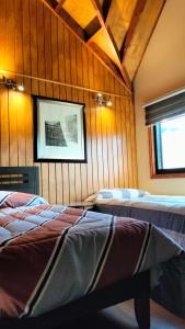 a room with three beds and a picture on the wall at Cabañas y Deptos Regional in Valdivia +58 photos