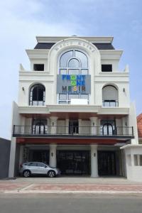 een gebouw met een auto ervoor geparkeerd bij Front One Hotel Mesir Surabaya in Surabaya