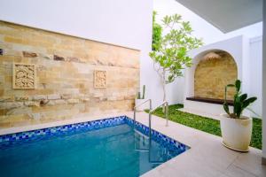 a swimming pool in a house with a brick wall at Danka Luxury Villa in Batam Center