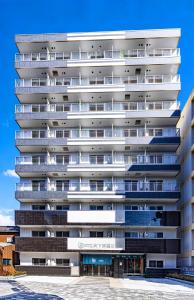 ein Mehrfamilienhaus mit Balkonen an der Fassade in der Unterkunft b&天下茶屋店 in Osaka