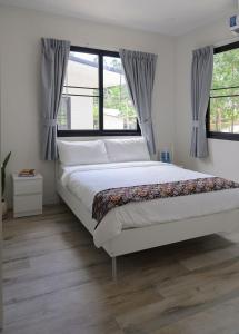 a bedroom with a large white bed and windows at Coconut Breeze Villa #2 in Haad Chao Phao +26 photos