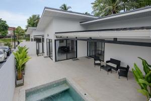 a house with a swimming pool in front of it at Coconut Breeze Villa #2 in Haad Chao Phao