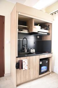 a kitchen with a wooden cabinet with a sink at Résidence Soavina in Antananarivo +20 photos