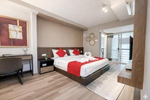 a bedroom with a bed and a desk and a chair at Panoramic Sea view 2BR Duplex High Floor George Town 203A Maritime Suite in George Town