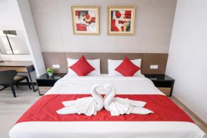 2 cygnes blancs assis sur un lit avec des oreillers rouges dans l'établissement Maritime Suites High-Floor full Seaview 2BR in Georgetown Pool Gym, à George Town 32 autres photos
