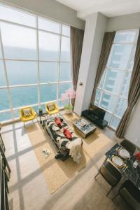 - un salon avec un canapé et de grandes fenêtres dans l'établissement Maritime Suites High-Floor full Seaview 2BR in Georgetown Pool Gym, à George Town