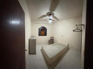 a room with a bed and a ceiling fan at Casa de praia in Itapemirim