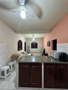 a kitchen with a counter top and a living room at Casa de praia in Itapemirim