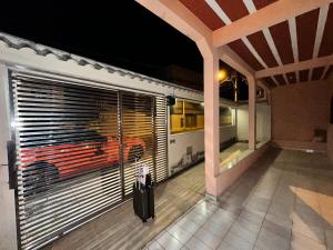 a suitcase is standing in front of a window with a train at Casa de praia in Itapemirim