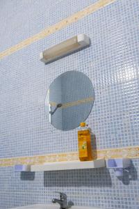 a bathroom with a mirror on a tiled wall at Camara Homes in Saint-Louis