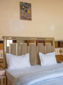 a large bed with white pillows in a room at Camara Homes in Saint-Louis
