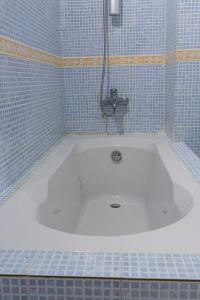 a bath tub in a bathroom with blue tiles at Camara Homes in Saint-Louis
