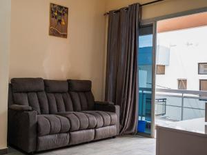 a brown couch in a living room with a window at Camara Homes in Saint-Louis