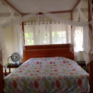 1 dormitorio con 1 cama grande y ventana en Liwayway sa Bohol Pamilacan Resort, en Baclayon