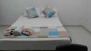 een bed met kussens en een deken erop bij Boutique Real PRB in Barrancabermeja