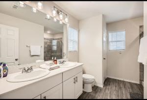 a white bathroom with two sinks and a toilet at Modern Retreat with Private Office in Heath +12 photos