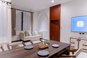 a living room with a table and a couch at Merry Holmes Resort Hatyai in Ban Tha Sae