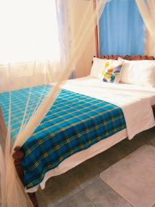 a bedroom with a bed with a mosquito net at Milly's apartment in Malindi