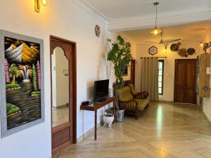 een hal met een woonkamer met een tv en een bank bij Fire Room Elements by Hexa stays in Trivandrum