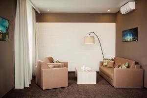 a living room with two chairs and a table at Hotel Versailles in Lutsk