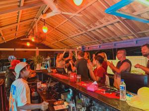 a group of people standing at a bar at Blue Shore Pavilion in Koh Rong Island