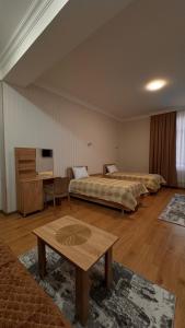 a large room with two beds and a table at RAA apartments in Qusar