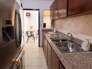 a kitchen with a sink and a stainless steel refrigerator at Haven Villa Retreat Jacuzzi Oasis in Mata los Indios