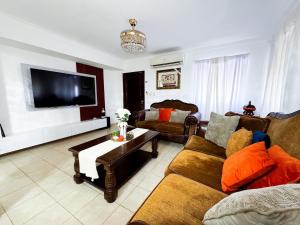 a living room with a couch and a tv at Haven Villa Retreat Jacuzzi Oasis in Mata los Indios