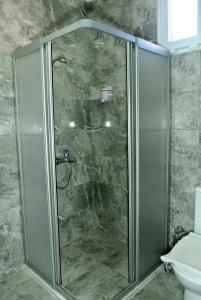 een douche met een glazen deur in een badkamer bij Emirhan Guesthouse & Suites in Istanbul