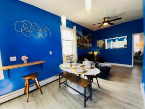 ein Esszimmer mit blauen Wänden sowie einem Tisch und Stühlen in der Unterkunft NYC Oasis in Mott Haven
