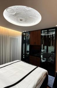 a bedroom with a bed and a chandelier at Feel Home Apartment in Kamëz
