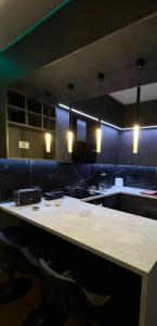 a kitchen with a large table with chairs and lights at Feel Home Apartment in Kamëz