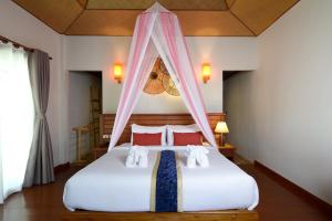 a bedroom with a bed with a canopy at PingChan Koh Phangan Beachfront Resort in Thong Nai Pan Yai