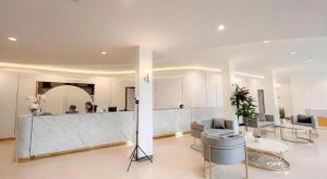 a living room with a counter and a person in a room at The Room Hotel in Ban Nong Puk