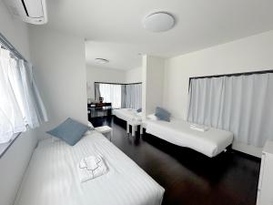 a hotel room with two beds and a desk at D旅館　Dryokan in Tokyo