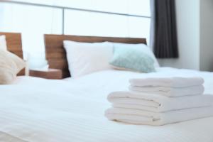 een stapel handdoeken gestapeld op een bed bij KAMINARI Inn Newly Renovated Jan 2026 in Tokyo +82 foto's