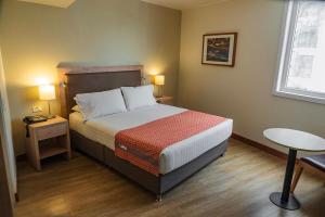 a bedroom with a bed and a table and a window at Xima Lima San Isidro in Lima +47 photos