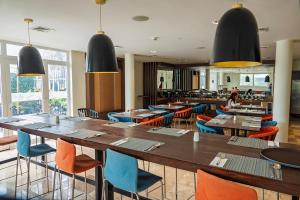 una sala da pranzo con tavoli e sedie e un ristorante di Xima Lima San Isidro a Lima