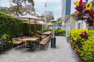 un patio con tavoli, sedie e ombrelloni di Xima Lima San Isidro a Lima
