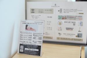 een bord dat op een tafel voor een poster staat bij KAMINARI Inn Newly Renovated Jan 2026 in Tokyo