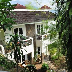 a white house with a balcony in front of it at Hotel Minahasa in Manado